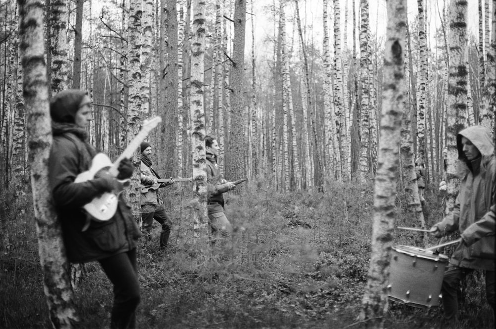 grayscale photo of playing middle bare tree