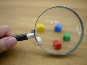 Close-up of hands shaking over a contract with colorful wooden toys in the background.