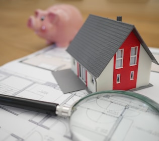 white and red wooden house beside grey framed magnifying glass