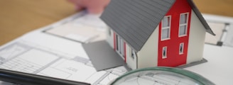 white and red wooden house beside grey framed magnifying glass