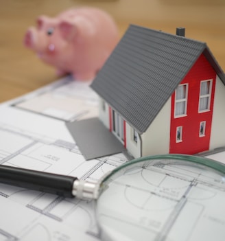 white and red wooden house beside grey framed magnifying glass