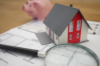 white and red wooden house beside grey framed magnifying glass