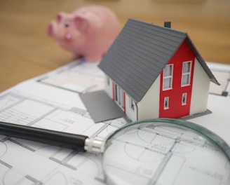 white and red wooden house beside grey framed magnifying glass