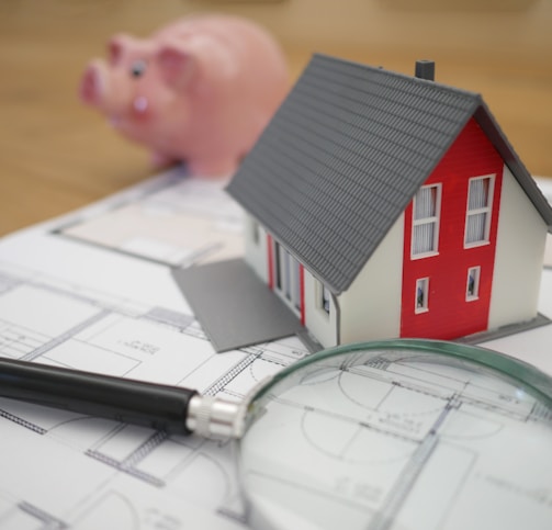 white and red wooden house beside grey framed magnifying glass