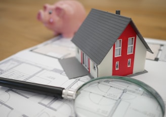 white and red wooden house beside grey framed magnifying glass