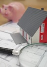 white and red wooden house beside grey framed magnifying glass