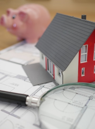 white and red wooden house beside grey framed magnifying glass