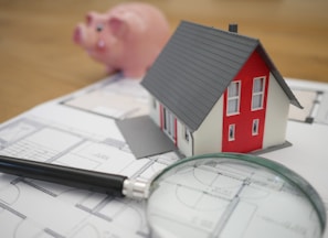 white and red wooden house beside grey framed magnifying glass