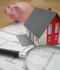 white and red wooden house beside grey framed magnifying glass