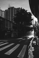Black and white cinematic shot of city streets at dawn with dramatic shadows.