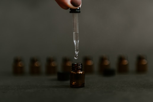 Close-up of a professional applying eye drops in a bright, clean lab setting