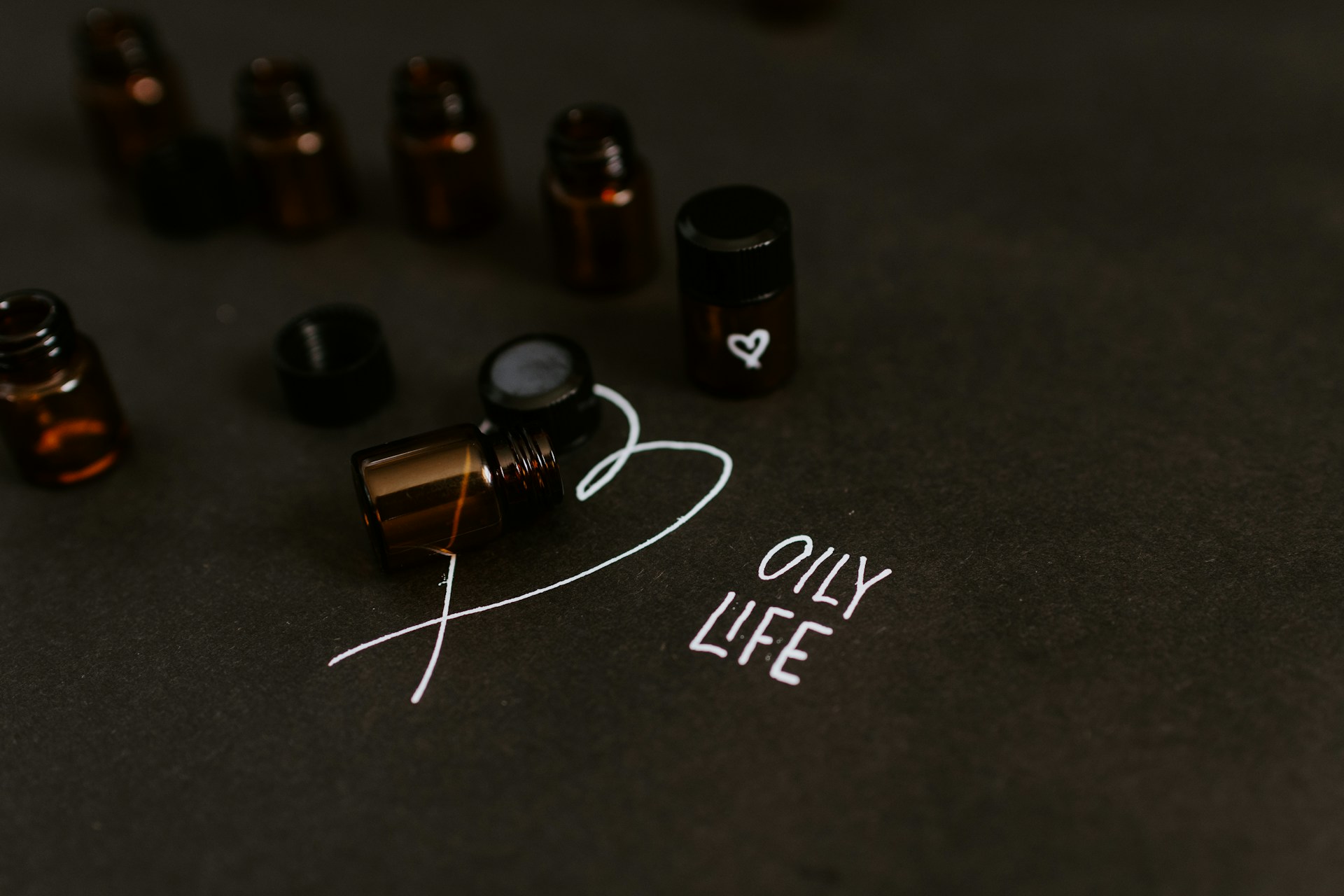 seven small bottle in black surface close-up photography