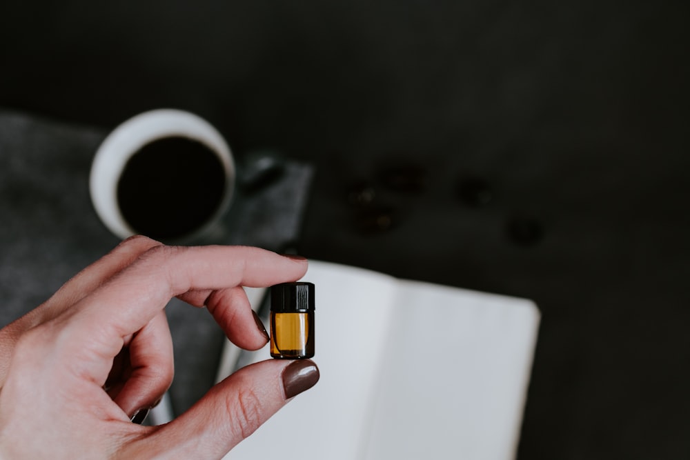 person holding small oil bottle