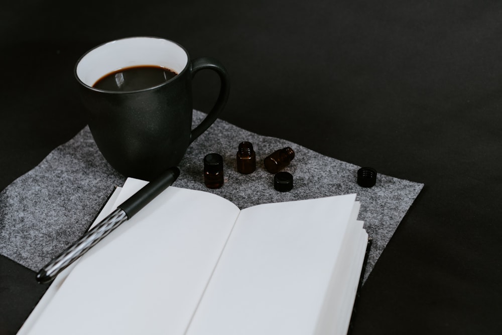 opened empty book beside cup of coffee