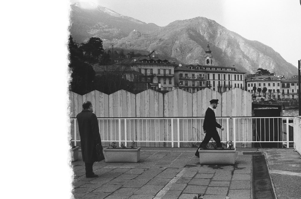 men walking beside fence