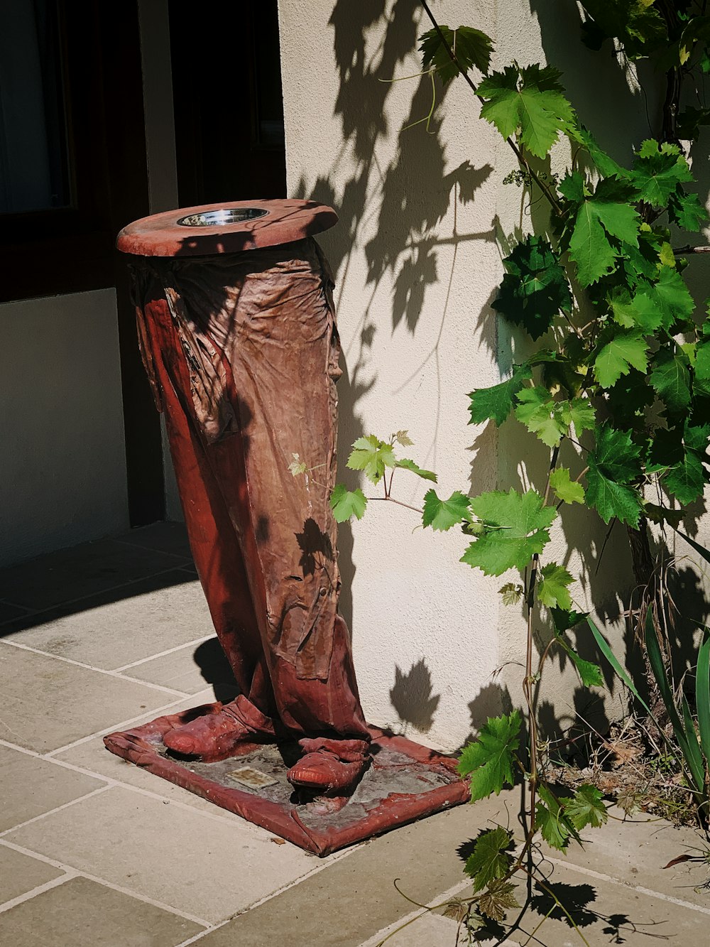 brown ceramic stand near green-leafed plant during daytime