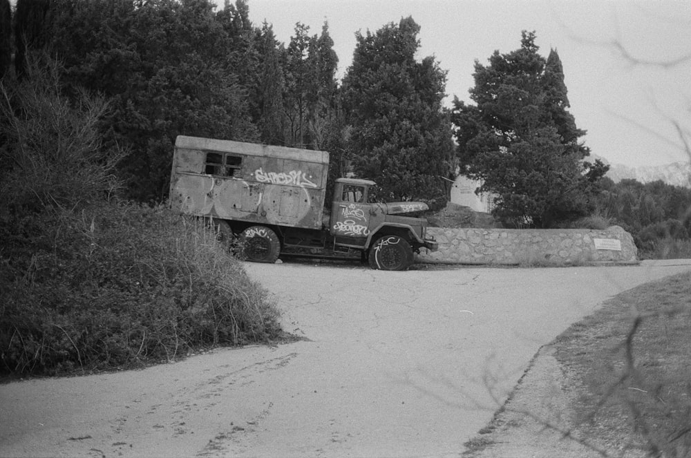 box truck parked beside pine trees