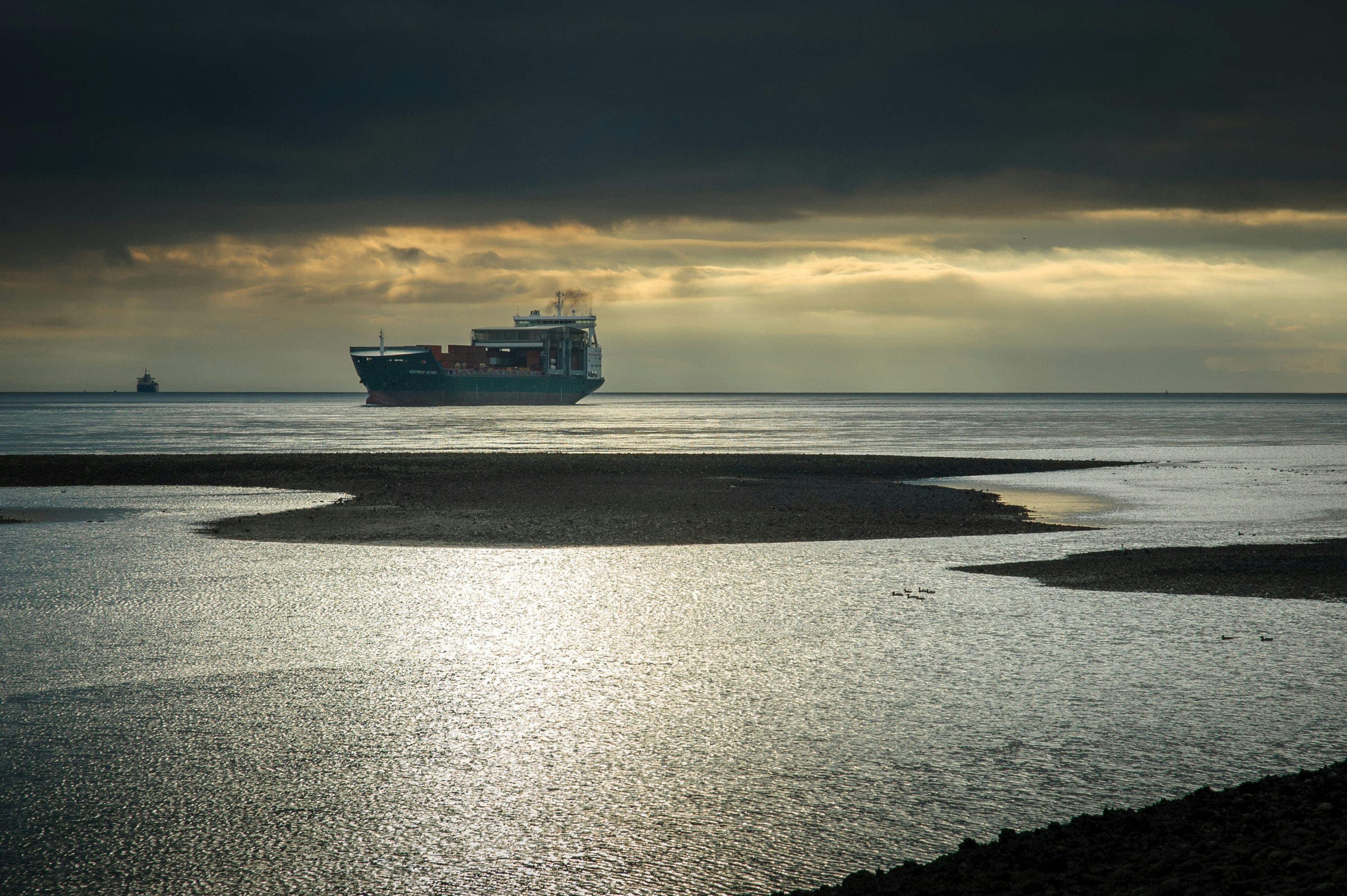 cruise ship on body of water under cloudy sky