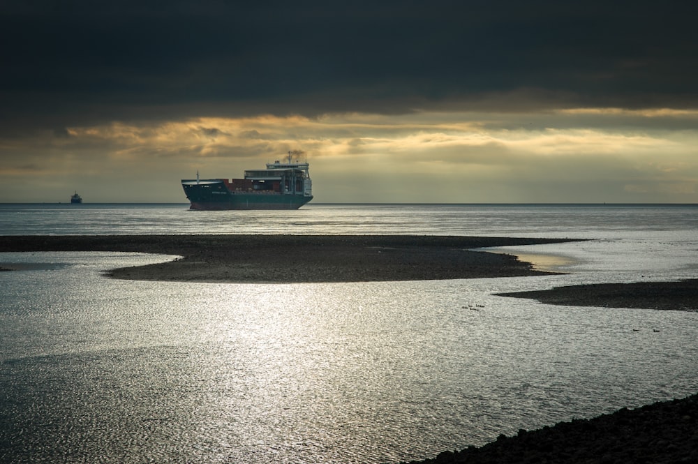 cruise ship on body of water under cloudy sky