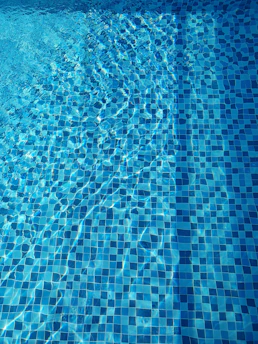 Close-up of a sparkling clean pool surface under bright Arizona sunlight.