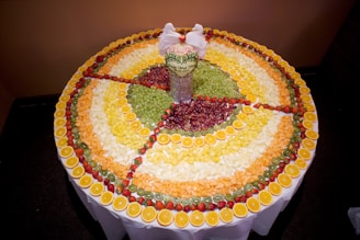 A close-up of colorful handcrafted fruit decorations arranged on a wooden table.