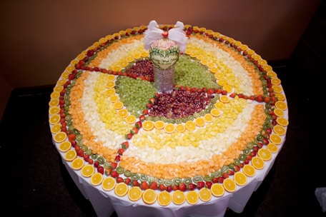 A close-up of colorful handcrafted fruit decorations arranged on a wooden table.
