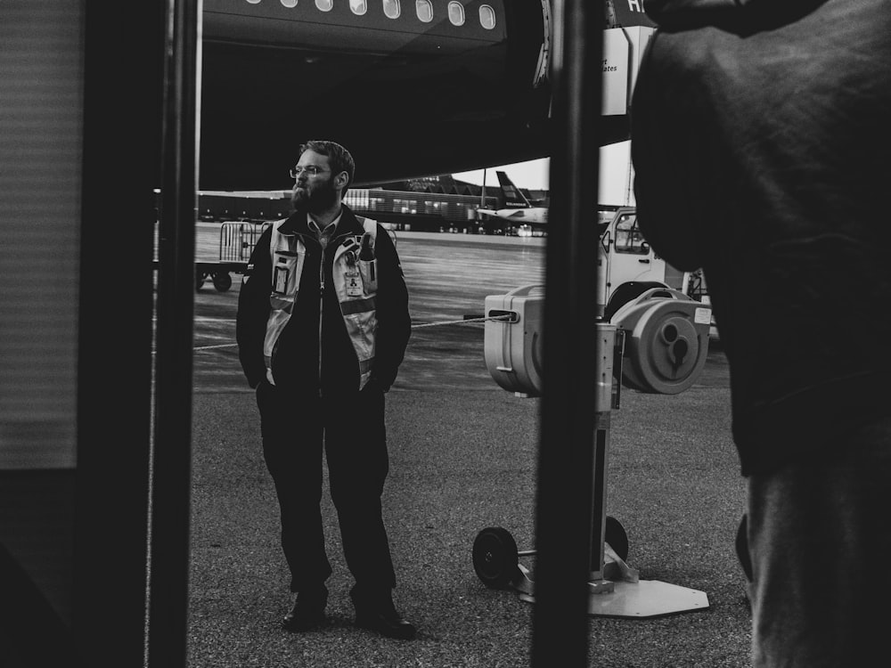 Un uomo in piedi di fronte a un aeroplano