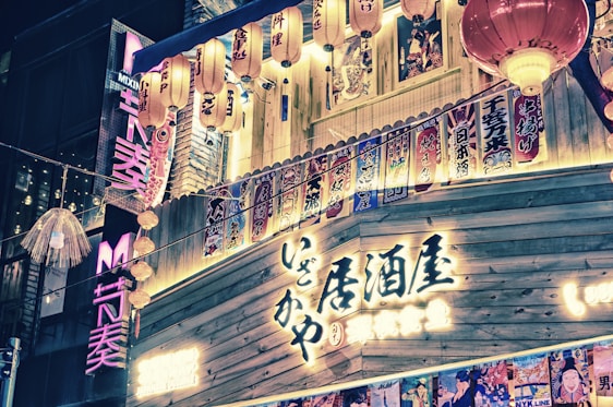 A vibrant street scene in Tokyo with colorful lanterns and bustling crowds at dusk.