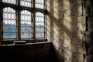 a window in a stone building with a view of a city