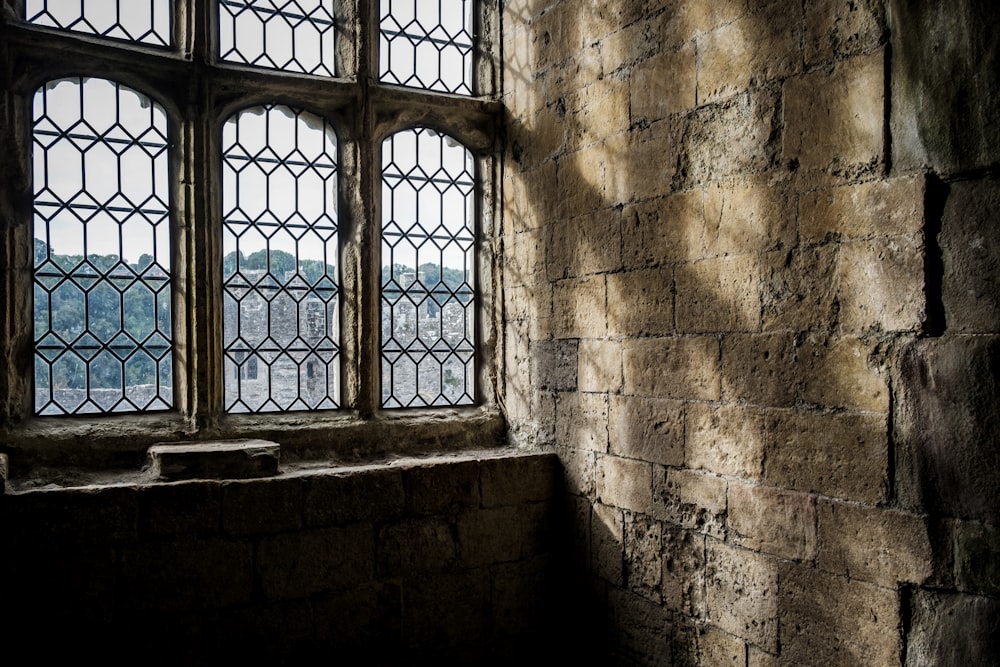 a window in a stone building with a view of a city