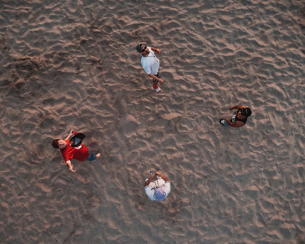 four person stand on beach sand
