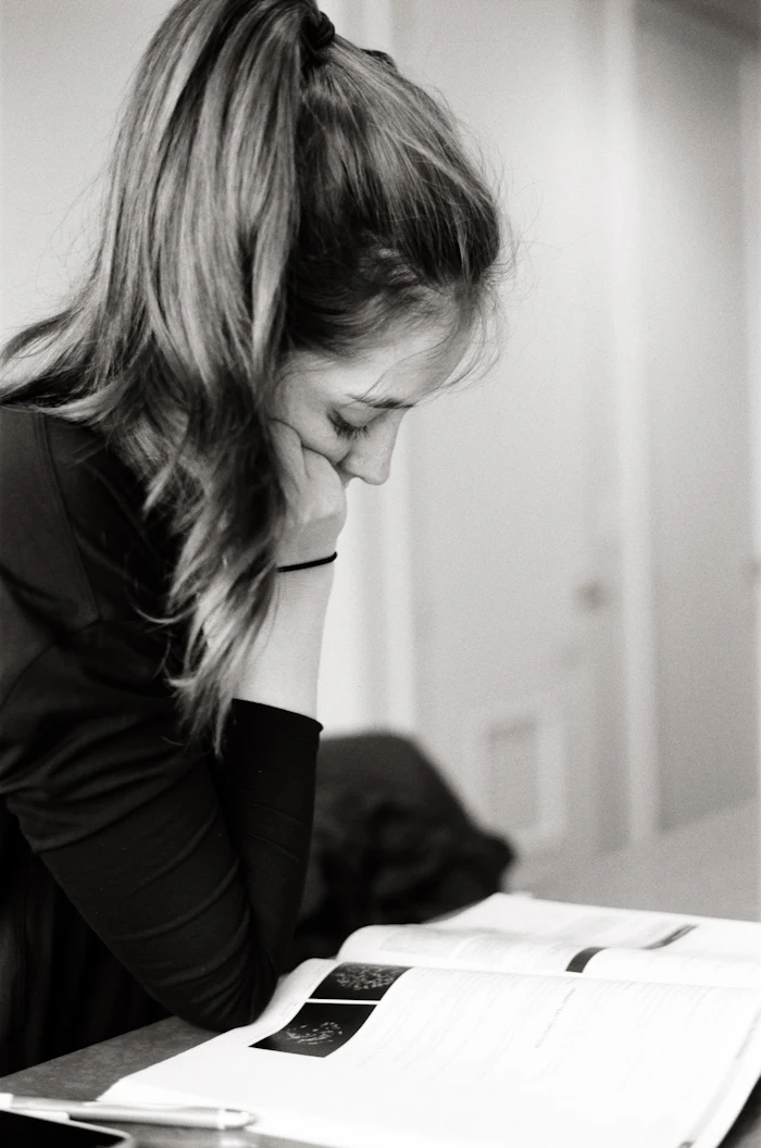 Person resting her head in her hand at a desk, tired