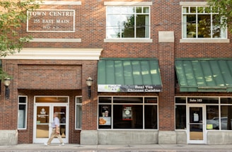 person walking in front of store front during daytime