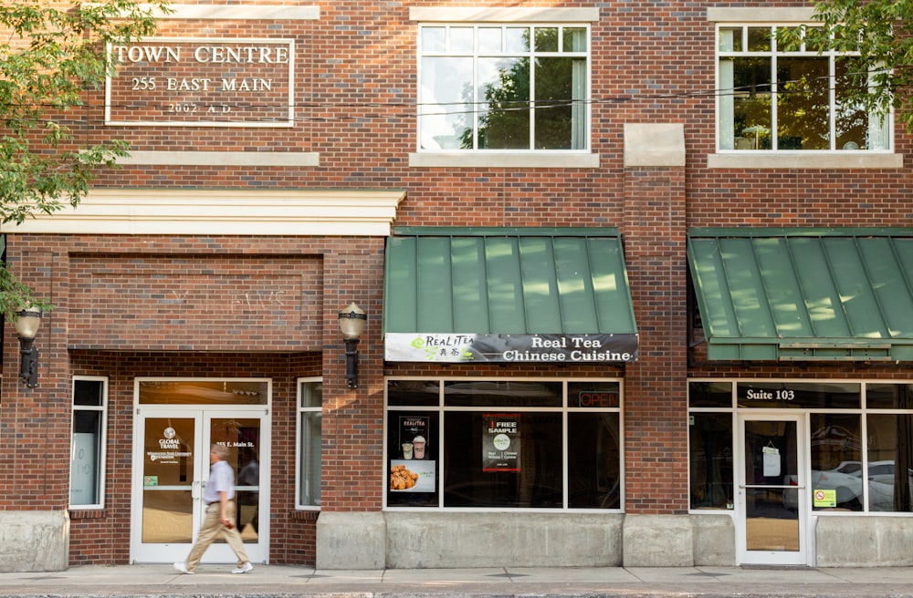 person walking in front of store front during daytime