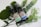 Two brown spray bottles labeled 'Pharma Hemp' placed on a bed of green leaves and surrounded by mossy and leafy decorations. One bottle is marked 'unflavored' and the other 'peppermint'. The layout is aesthetically arranged with a natural, organic vibe.