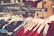 A clothing rack filled with various garments on hangers, with a prominent display of red and floral patterns. The focus is on neatly organized clothes in a retail setting, highlighting the variety and arrangement.