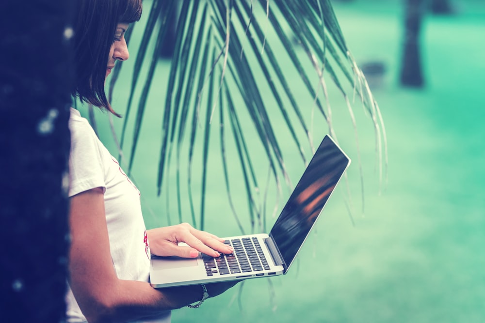 woman standing and using MacBook Air