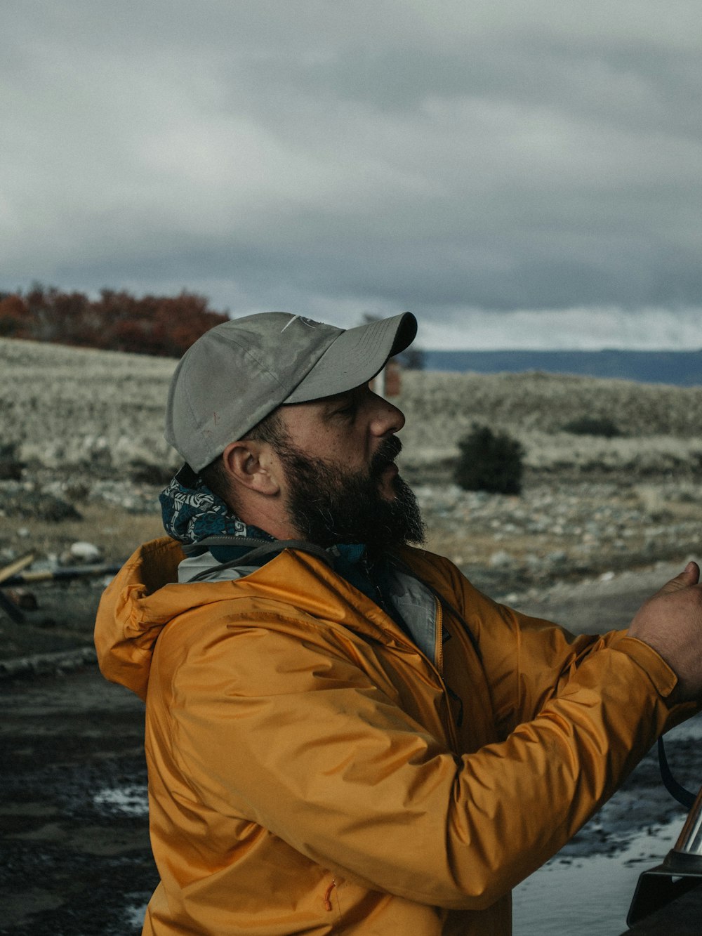 man in gray cap standing on river