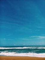 A scenic view of a tranquil beach with gentle waves and clear skies.