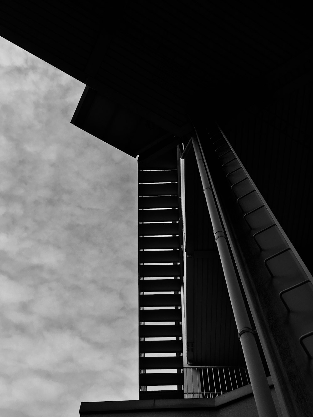 grayscale photo of building under cloudy sky