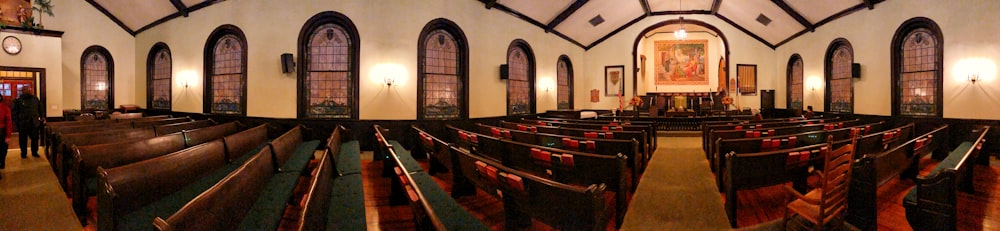 a large church with rows of pews and a painting on the wall