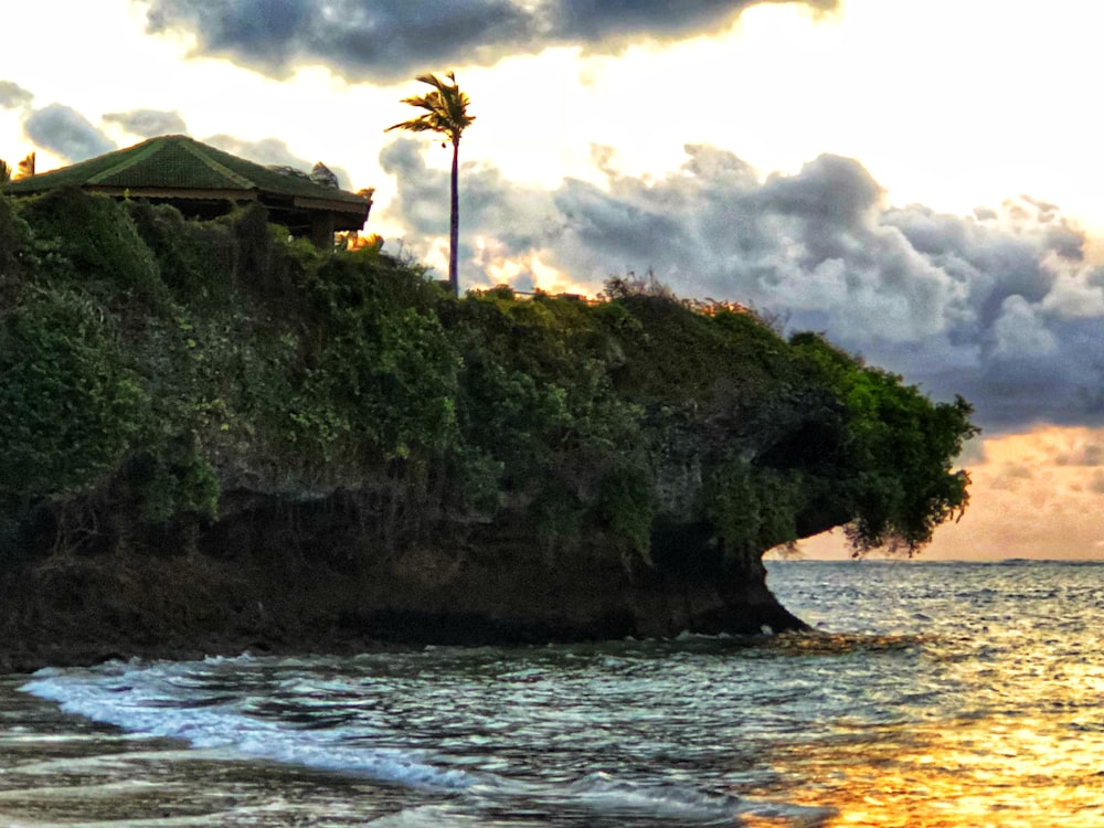 house near beach cliff viewing sea under gray skies