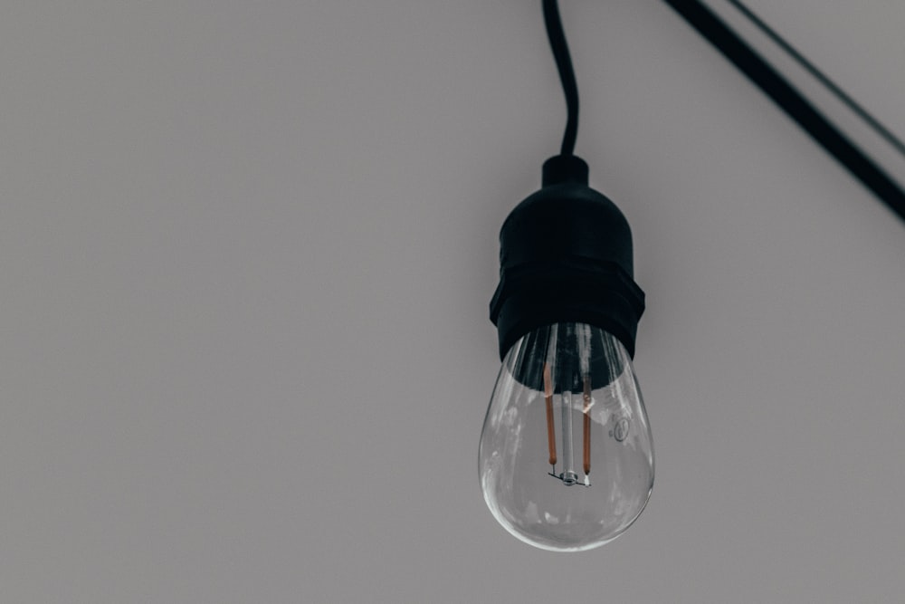 a light bulb hanging from a black cord