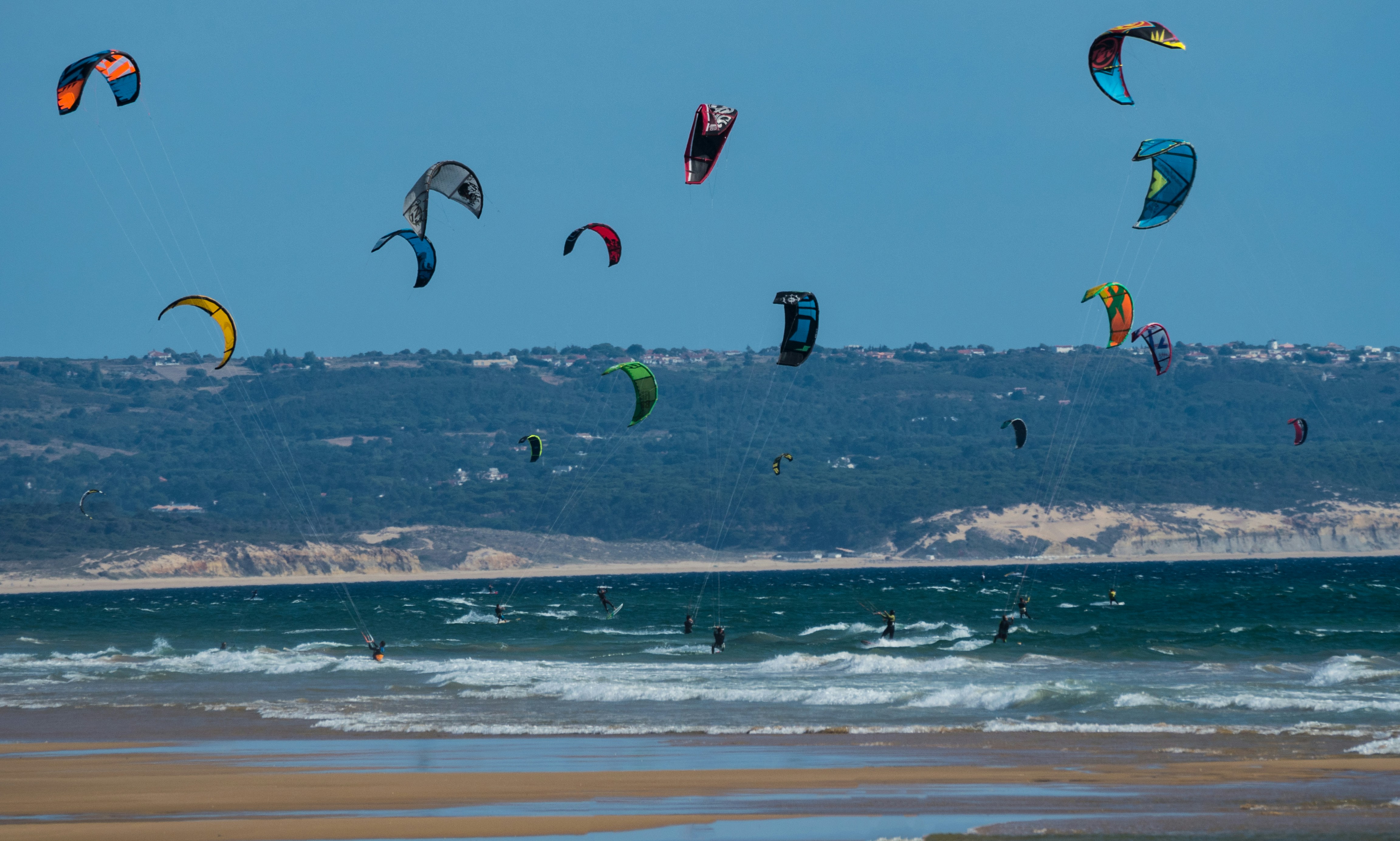 people paragliding near body of water