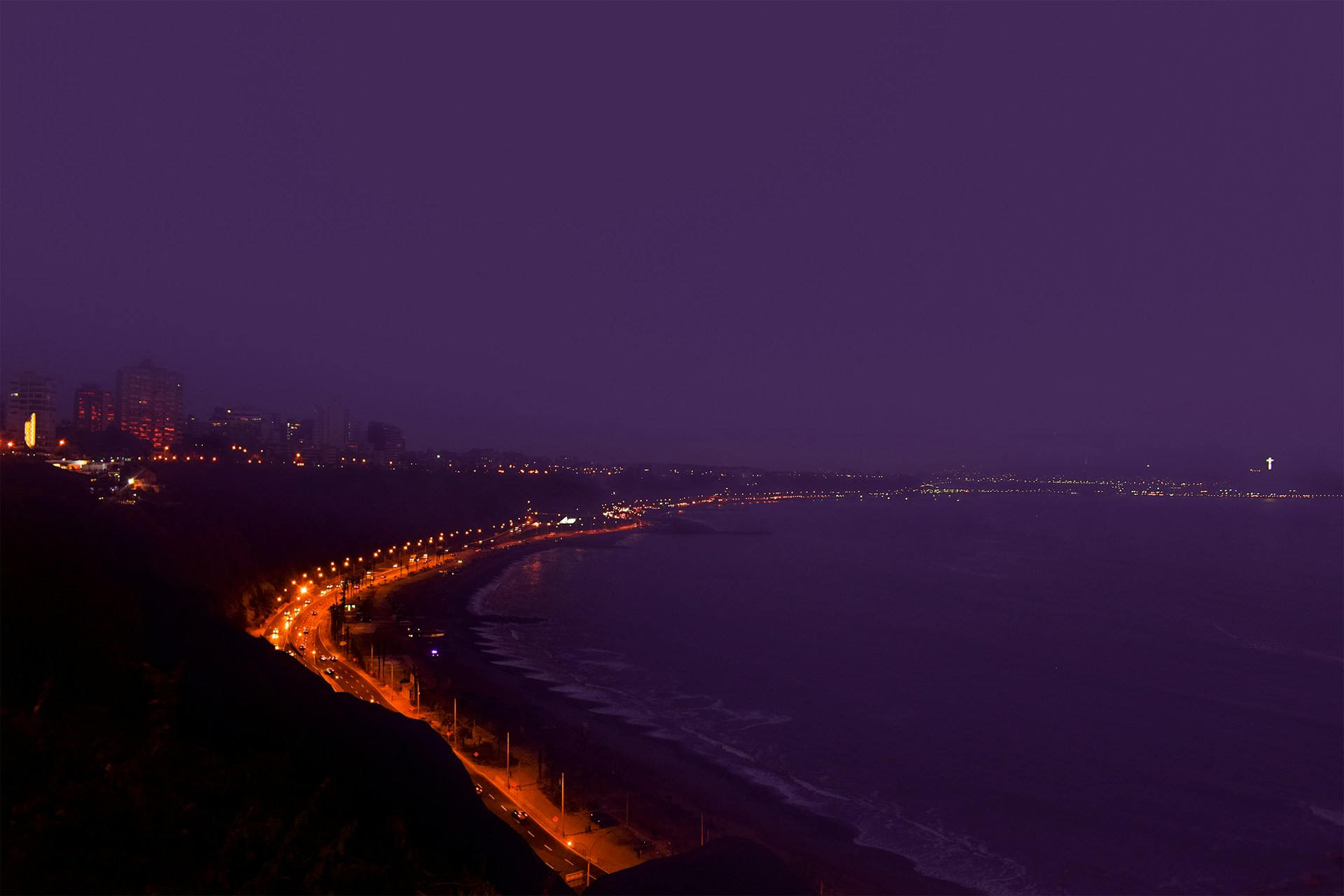 lighted building near sea during nighttime