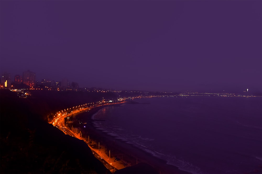 lighted building near sea during nighttime