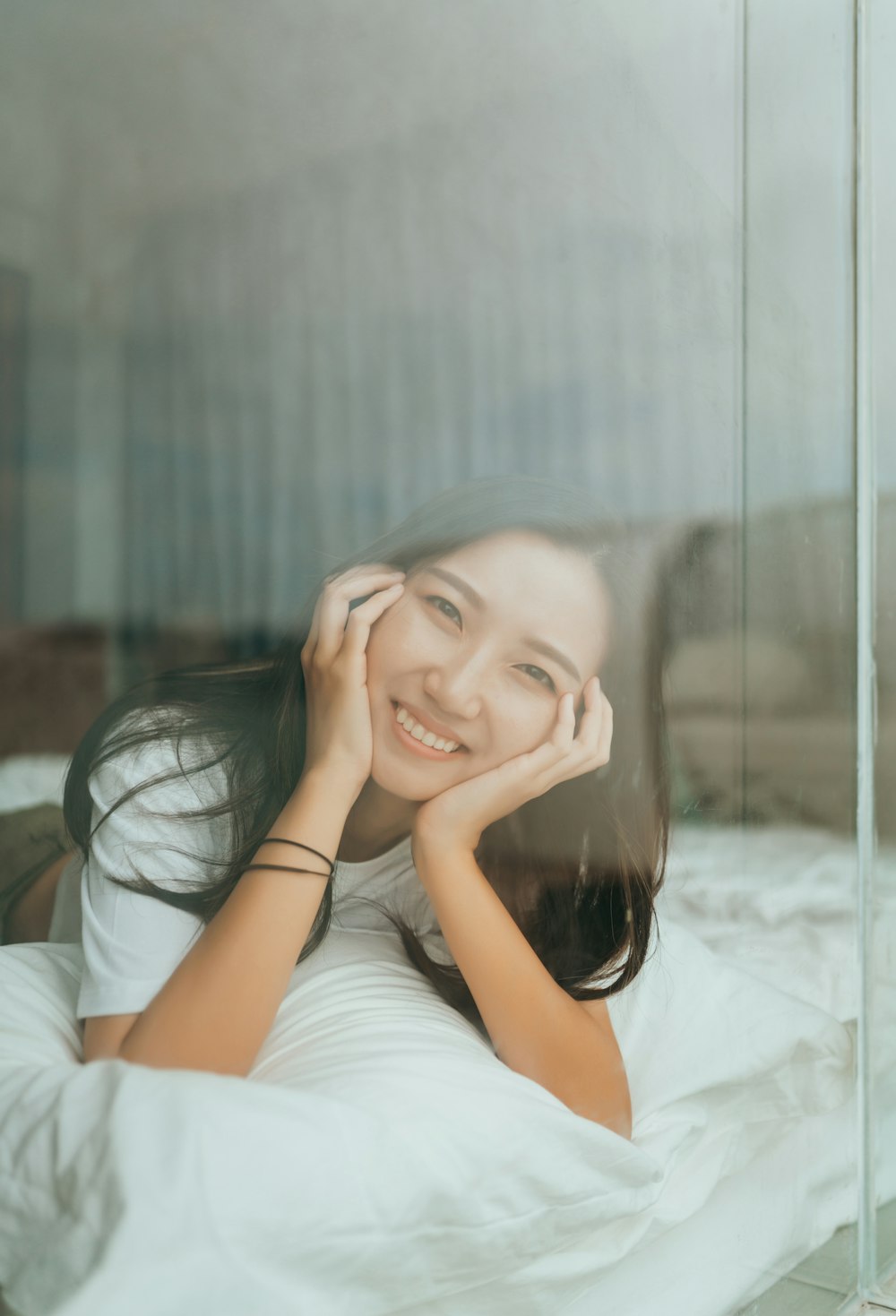 shallow focus photo of woman in white crew-neck T-shirt smiling