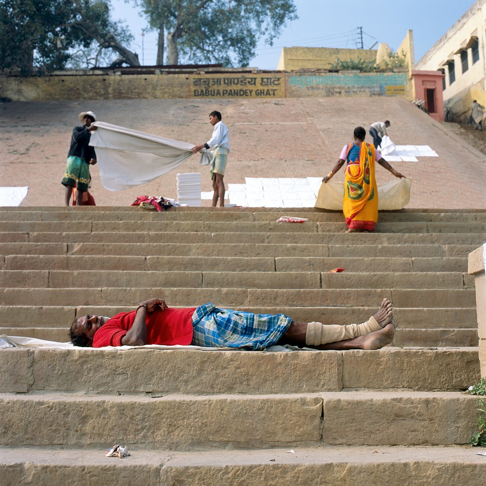man lying on brown stair
