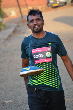 Female runner crossing the finish line with a smile in a 10 km race.