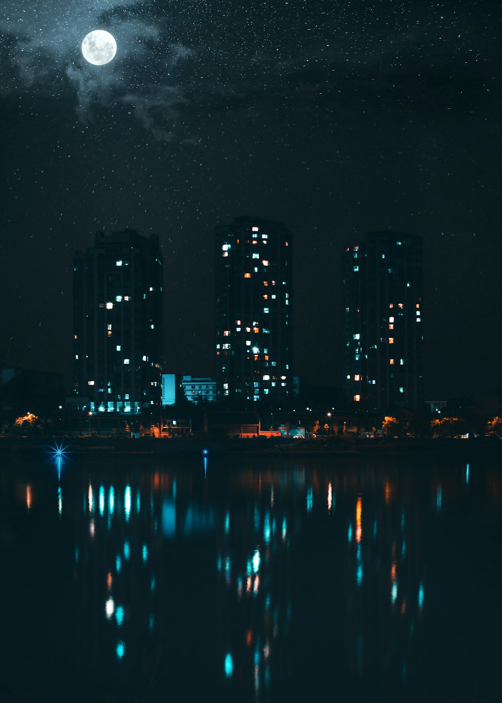 lighted building reflection on body of water during night